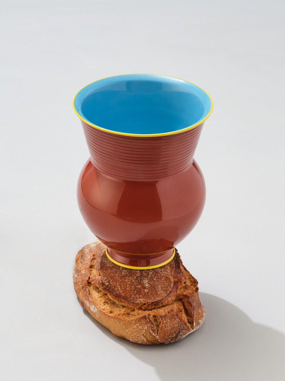 KPM+ Gisbert Pöppler Halle Vase mit blauem Oberteil, rotem Körper und Holzsockel.