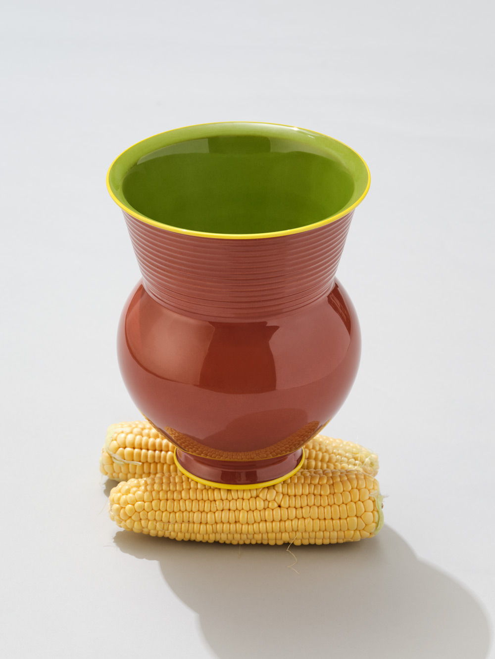 Eine KPM+ Gisbert Pöppler Halle Vase, die auf einem Stück Mais steht.